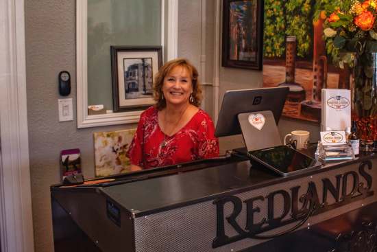 Dianna Lawson, Ed Mansion Memories and Redlands conservacy outdoor ambassador, smiling at the front desk